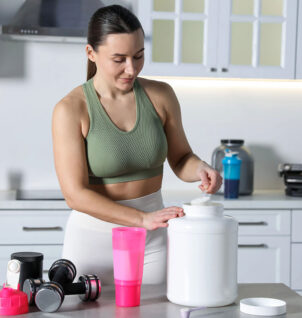 Fitness trainer adding protein supplement to a beverage.