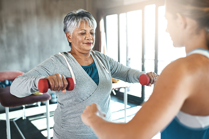 Fitness trainer coaching a senior citizen.